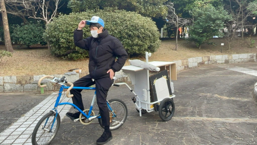 開店前後の櫻井氏。自転車で移動します。